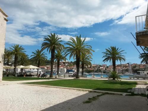 a park with palm trees and a body of water at Studio Kairos in Trogir