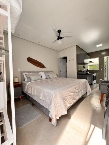 a bedroom with a large bed with a ceiling fan at La Estancia Residencial in Iguape
