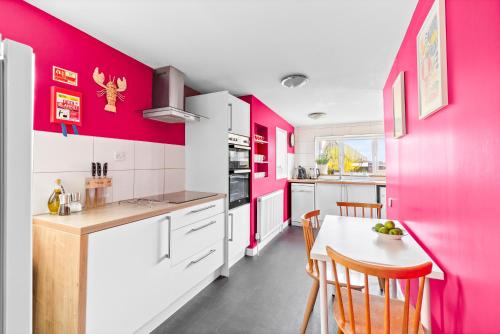 cocina con paredes rosas, mesa y sillas en The Old Jewellers, en Tayport