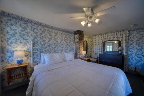 a bedroom with a large bed with blue wallpaper at Downtown Parking Room With a View Piedmont in Eureka Springs