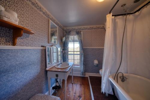 a bathroom with a tub and a sink and a bath tub at Downtown Parking Room With a View Piedmont in Eureka Springs
