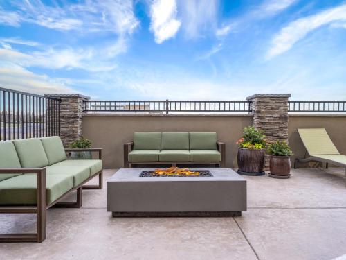 a patio with two chairs and a fire pit at La Quinta Inn and Suites by Wyndham Lincoln in Lincoln