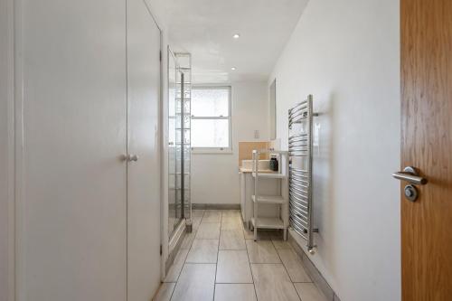a room with a hallway with a refrigerator and a door at The London Loftscape in London