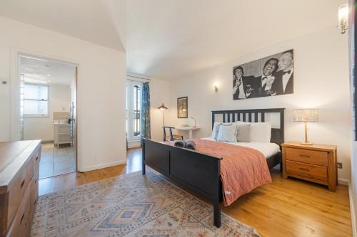 a bedroom with a large bed with a orange bedspread at The London Loftscape in London