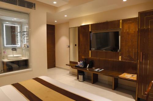 a hotel room with a television and a bathroom at Hotel Grand Plaza in City Centre - Walking Distance From New Delhi Railway Station and Connaught Place in New Delhi