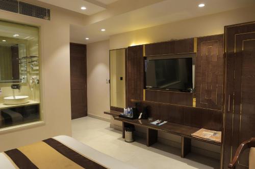 a hotel room with a television and a bed in a room at Hotel Grand Plaza in City Centre - Walking Distance From New Delhi Railway Station and Connaught Place in New Delhi