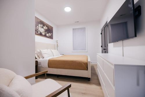 a bedroom with a bed and a tv in a room at Parisian Retreat 6min to Main Quandrangle U of C in Chicago