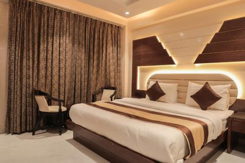 a bedroom with a large bed and a chair at Hotel Grand Plaza in City Centre - Walking Distance From New Delhi Railway Station and Connaught Place in New Delhi