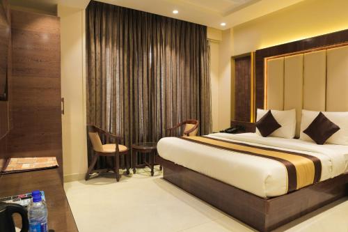 a hotel room with a bed and a table and chairs at Hotel Grand Plaza in City Centre - Walking Distance From New Delhi Railway Station and Connaught Place in New Delhi