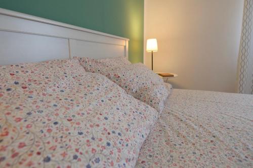 a bedroom with a bed with a floral bedspread at Quiet House - appartamento Maestrale in Porto Torres