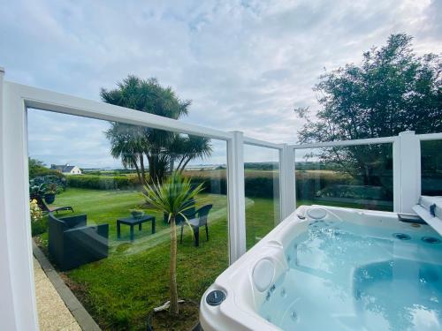 une baignoire jacuzzi devant une grande fenêtre dans l'établissement Ty Névez, à Sibiril