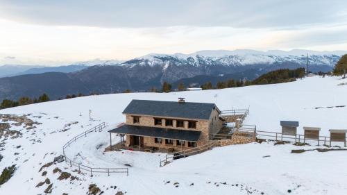a building on top of a snow covered mountain at Refugi de l'Arp in Montargull de la Vansa
