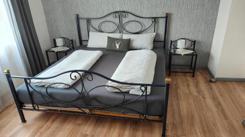 a bed with a black metal frame and two night stands at Moderne Wohnung in Achern, Schwarzwald in Achern