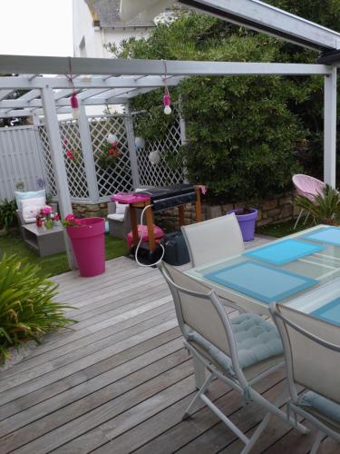 un patio avec une table et des chaises sous une pergola dans l'établissement Villa cocooning, à Saint-Pierre-Quiberon