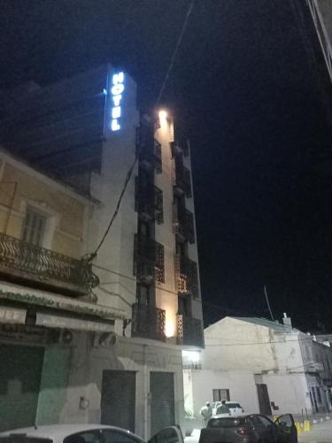 a tall building with a sign on it at night at Hôtel Tlemcen médina in Tlemcen
