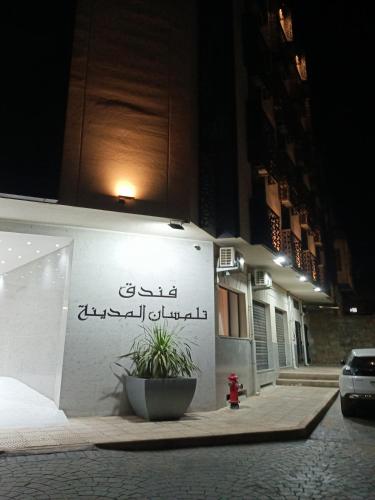 a building with writing on the side of it at night at Hôtel Tlemcen médina in Tlemcen