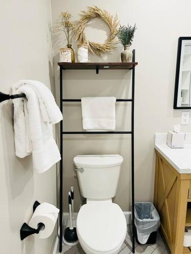 a bathroom with a toilet and a shelf with towels at Lovely Studio In Downtown Stuart - Renovated #6 in Stuart