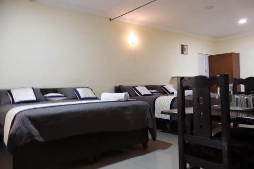a room with two beds and a chair in it at Bruton resorts in Kodaikānāl