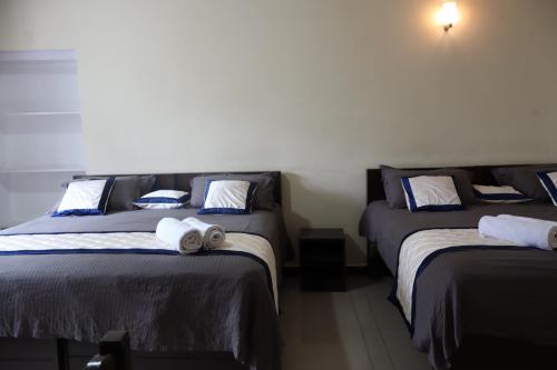 a room with three beds with towels on them at Bruton resorts in Kodaikānāl