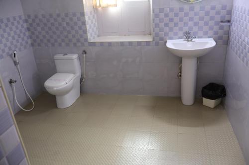 a bathroom with a toilet and a sink at Bruton resorts in Kodaikānāl