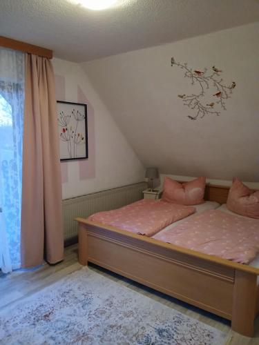 a bedroom with a bed with pink sheets and a window at Aparthotel Schafshorn in Schaprode