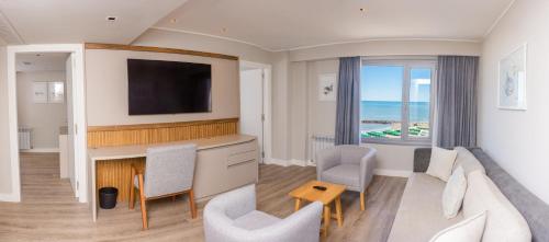 a living room with a couch and a tv at La Bancaria Hotel MDP in Mar del Plata