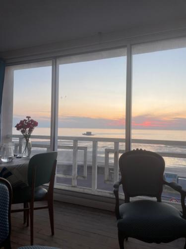 une salle à manger avec vue sur l'océan dans l'établissement La Plus Belle vue sur la Mer, à Le Portel