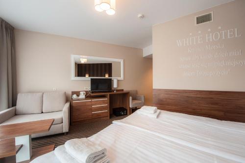 a hotel room with a bed and a couch at Hotel White in Krynica Morska