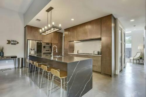 a kitchen with a counter and a bar with stools at Modern 2-Home Private Oasis w Pool Hot Tub in DT in Austin