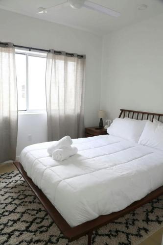 a bedroom with a large bed with white sheets and a window at Modern Condo w Patio City Views Heart of DT Austin in Austin