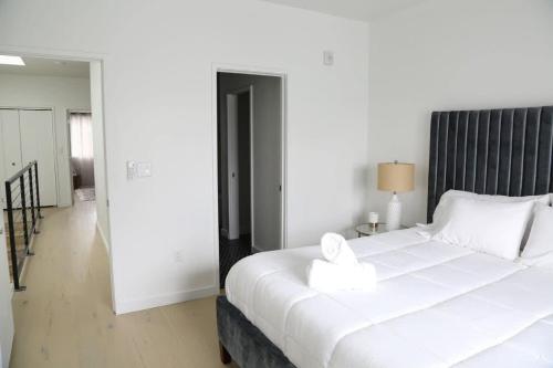 a bedroom with a large white bed with a black headboard at Modern Condo w Patio City Views Heart of DT Austin in Austin