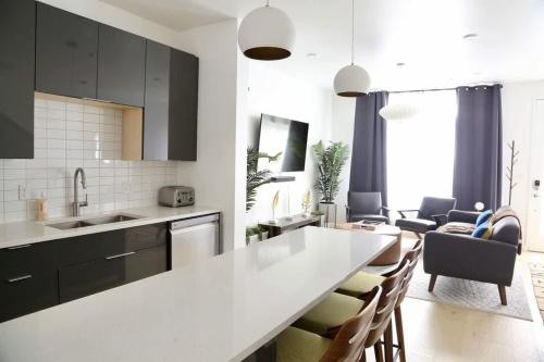 a kitchen with a white counter top and a living room at Modern Condo w Patio City Views Heart of DT Austin in Austin