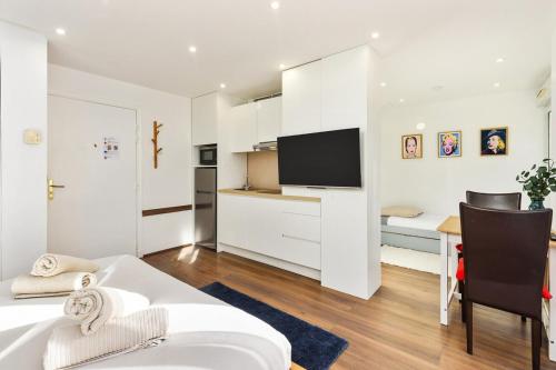 une chambre avec un lit et un bureau avec une télévision dans l'établissement Monte carlo riviera, à Beausoleil