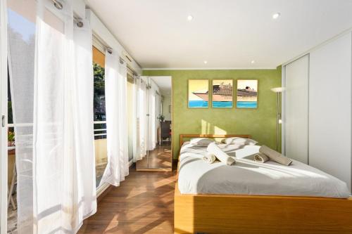 une chambre avec un lit et une grande fenêtre dans l'établissement Monte carlo riviera, à Beausoleil