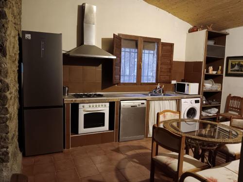 a kitchen with a black refrigerator and a table in it at Charming Farmhouse in Enguera, Spain with Private Pool and Mountain Views in Enguera
