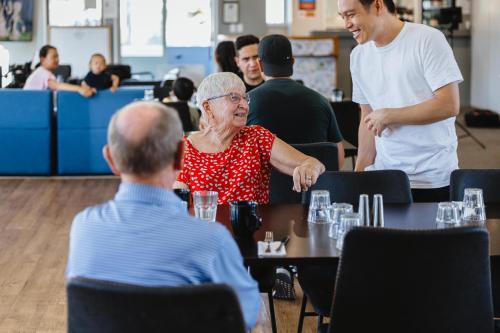 an older woman sitting at a table in a restaurant at Kennedy Park Resort Napier in Napier
