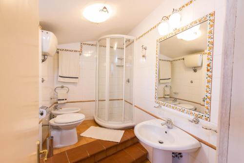 a bathroom with two toilets and a shower and a sink at Agriturismo la Vigna in San Gimignano