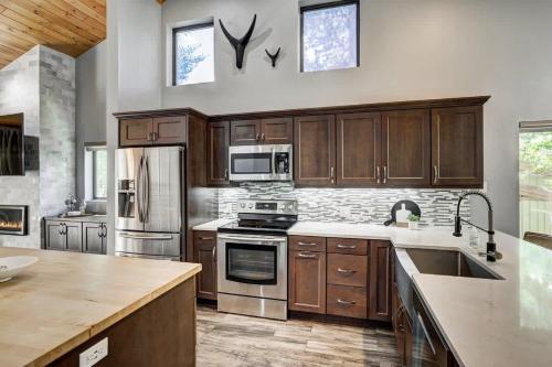 a kitchen with wooden cabinets and stainless steel appliances at Luxury Modern Townhome-Private Hot Tub-In Town in Breckenridge