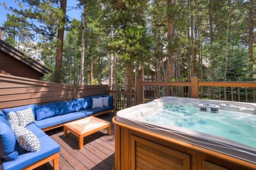 a jacuzzi tub on a deck with a blue couch at Luxury Modern Townhome-Private Hot Tub-In Town in Breckenridge