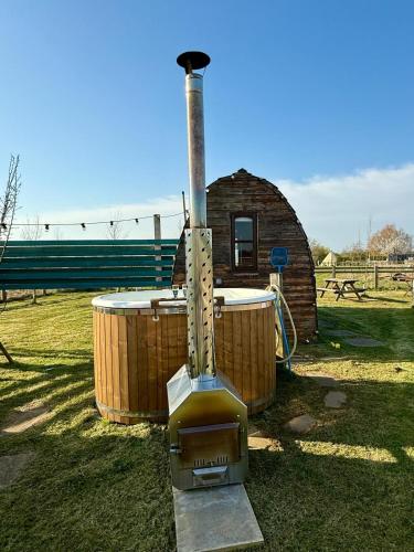a wood fired stove in front of a building at Skipbridge farm glamping in York
