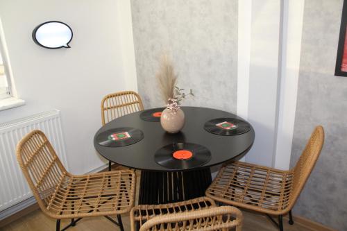 a black table with chairs and a vase on it at AP Apartment's Rodzinny in Wałbrzych