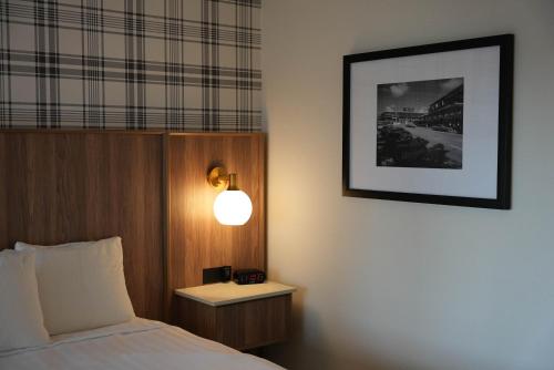 a bedroom with a bed and a lamp on a wall at Travelodge by Wyndham Niagara Falls At the Falls in Niagara Falls