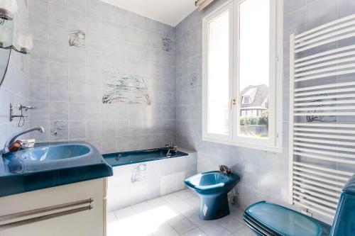 une salle de bain avec des toilettes bleues et un lavabo dans l'établissement Superb beach-front family house, à Merville-Franceville-Plage