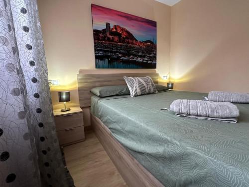 a bedroom with a bed and a painting on the wall at Alicante super center by Sunset in Alicante