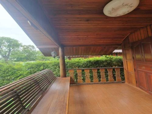 a porch with a wooden bench on a balcony at Metathsana Resort in Phra Nakhon Si Ayutthaya