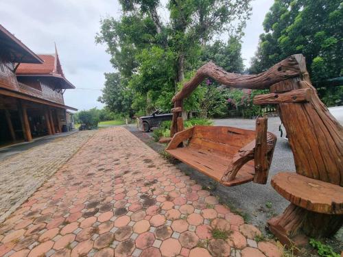 a wooden bench on the side of a street at Metathsana Resort in Phra Nakhon Si Ayutthaya