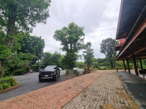 a car parked on the side of a brick road at Metathsana Resort in Phra Nakhon Si Ayutthaya