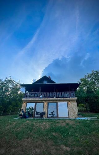 a house with a balcony on top of it at Forest Heaven Retreat with jakuzz in Čačak