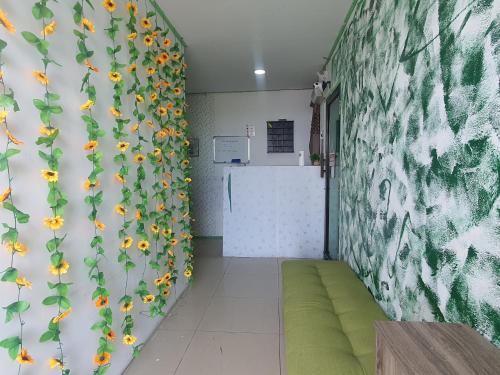 Hotel O Green Leaf Guest Lodge Kk في كوتا كينابالو: غرفة بها جدار مغطى بزهور الشمس