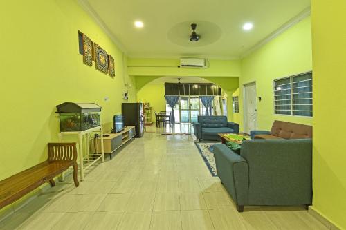 a living room with a couch and a fish tank at Hotel O Zn Mix Homestay & Roomstay in Kampung Raja
